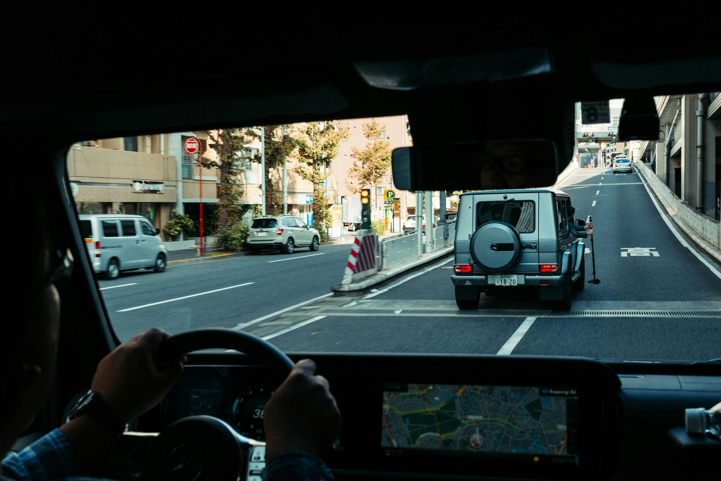 Silver Mercedes G-Class filmed with a rig from a following car on a Tokyo road