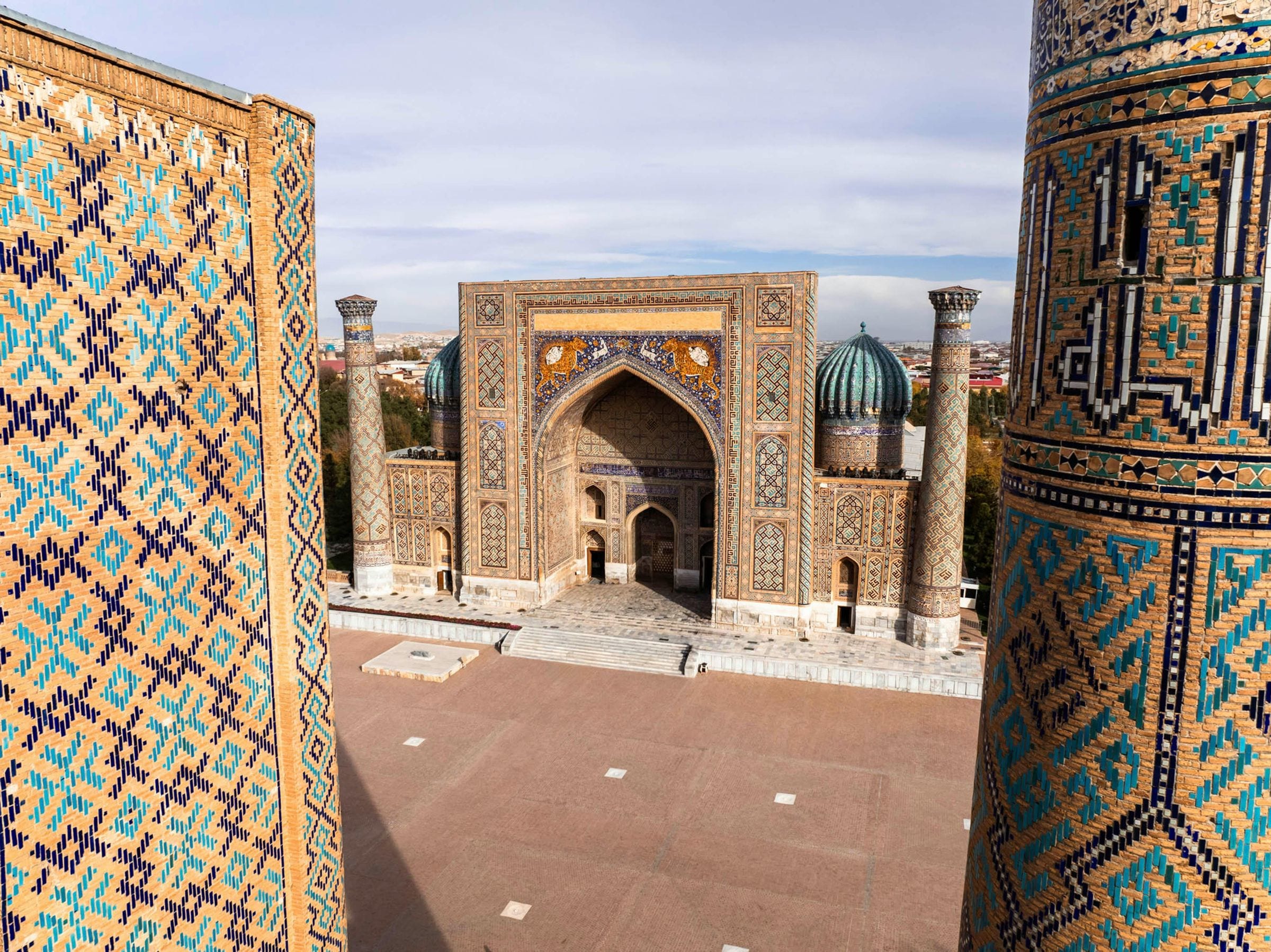 Elevated view of Samarkand's Registan, tiled portal with tiger mosaics framed by minarets