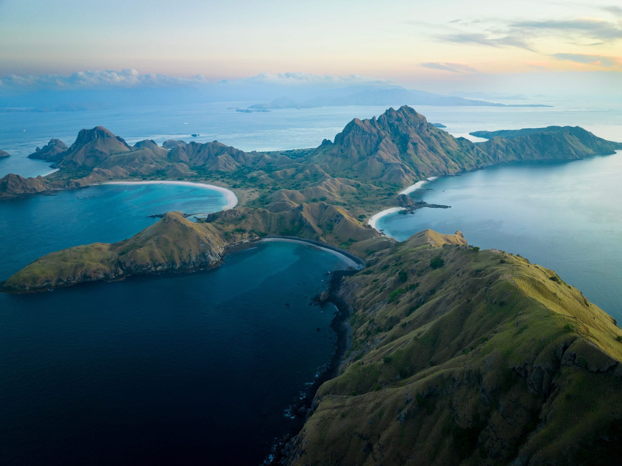 Shallow coral reefs glowing beneath a clear sea, aerial view