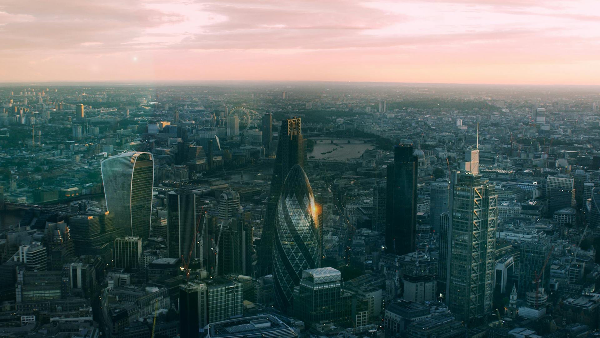 Aerial view of London's City skyline at dusk, the Gherkin catching sunset light