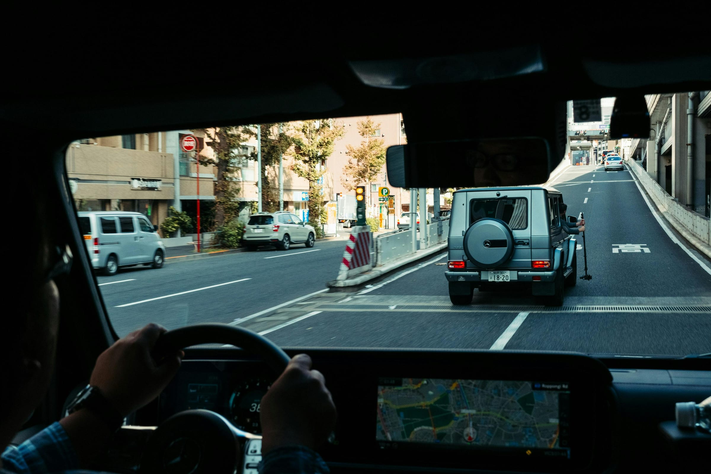 Silver Mercedes G-Class filmed with a rig from a following car on a Tokyo road