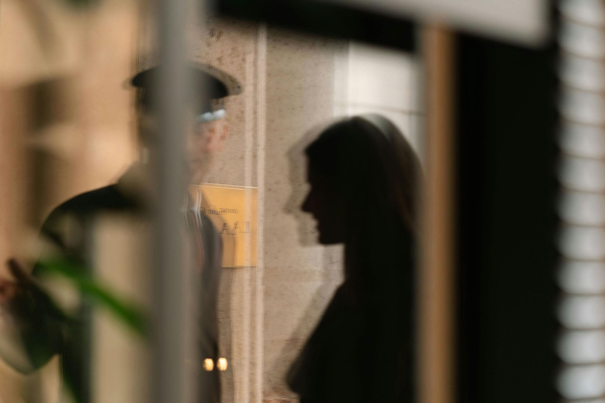 Doorman and woman reflected in glass beside Orient Express hotel signage