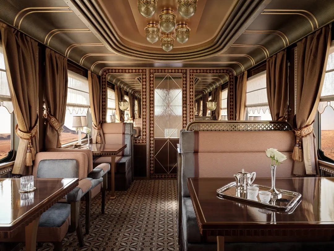 Ornate lounge car of a luxury train with chandelier and silver tea service