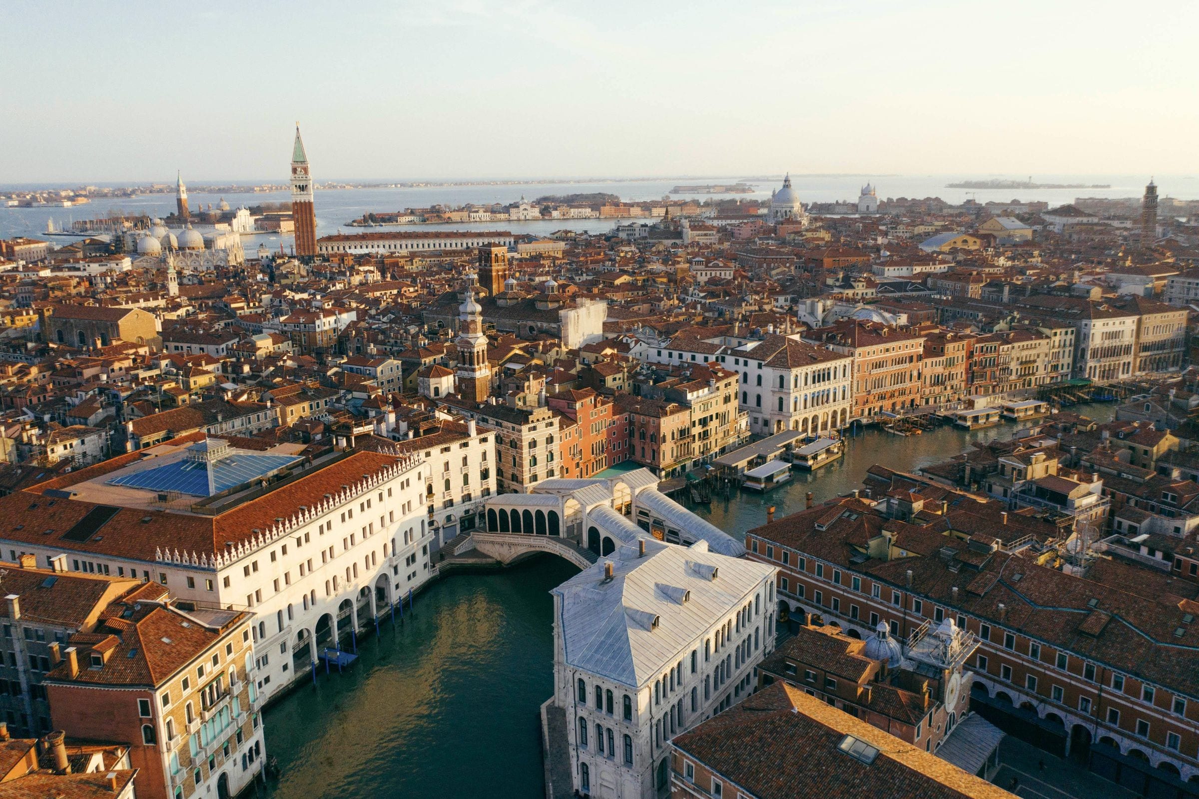Aerial of the Rialto Bridge spanning the Grand Canal, Venice rooftops toward the lagoon