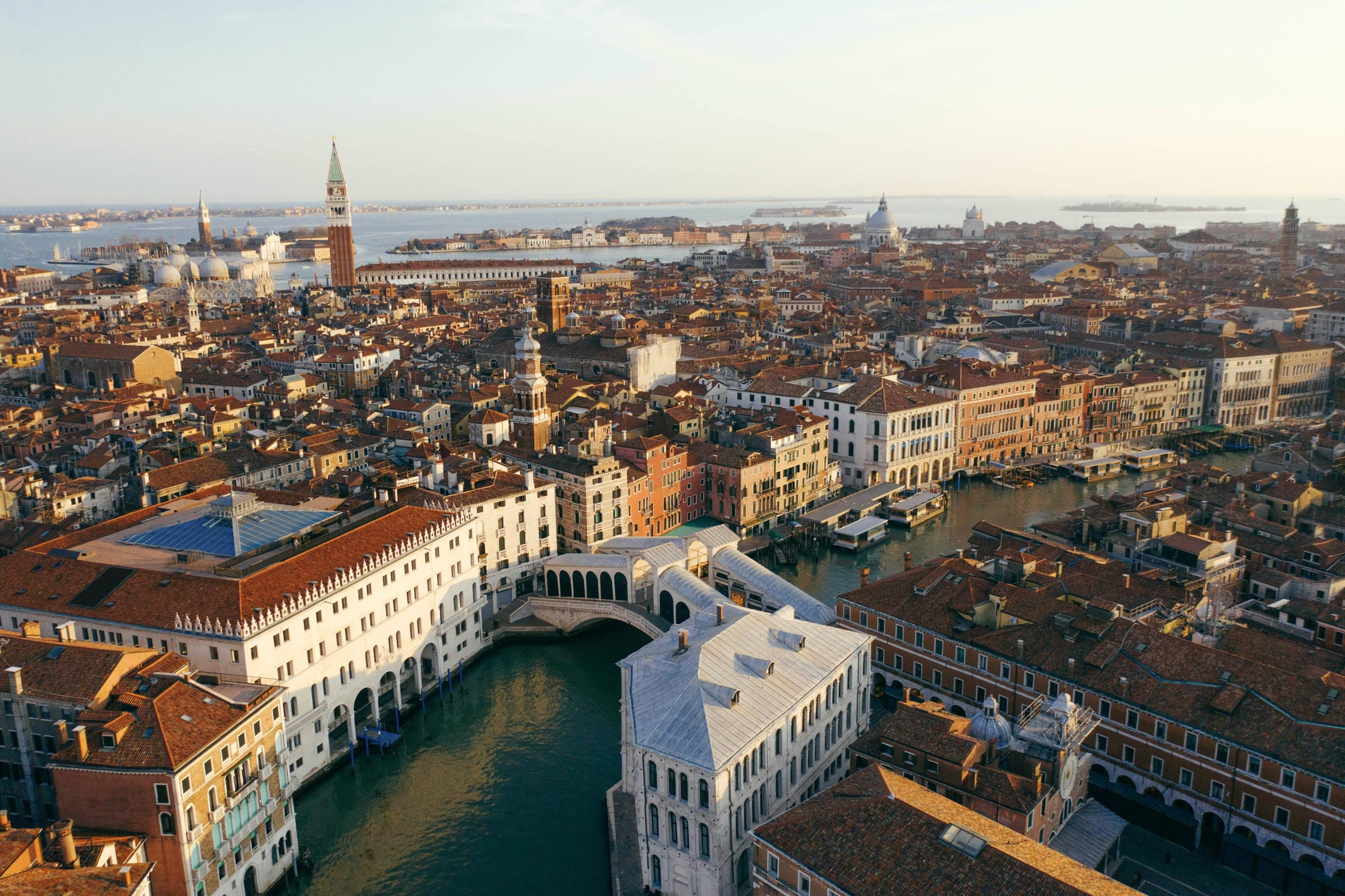 Aerial of the Rialto Bridge spanning the Grand Canal, Venice rooftops toward the lagoon