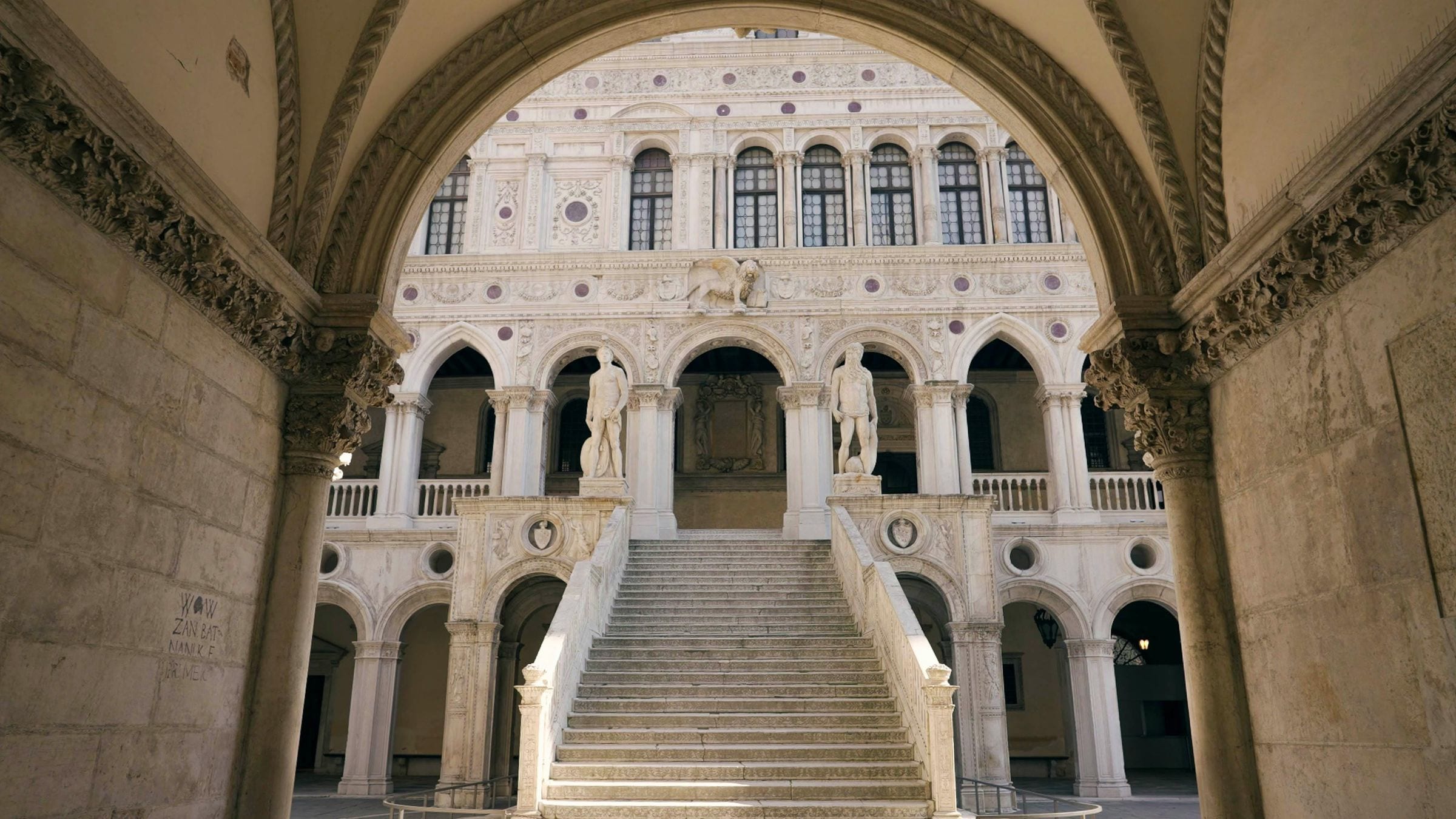Giants' Staircase in the Doge's Palace courtyard framed by a stone arch