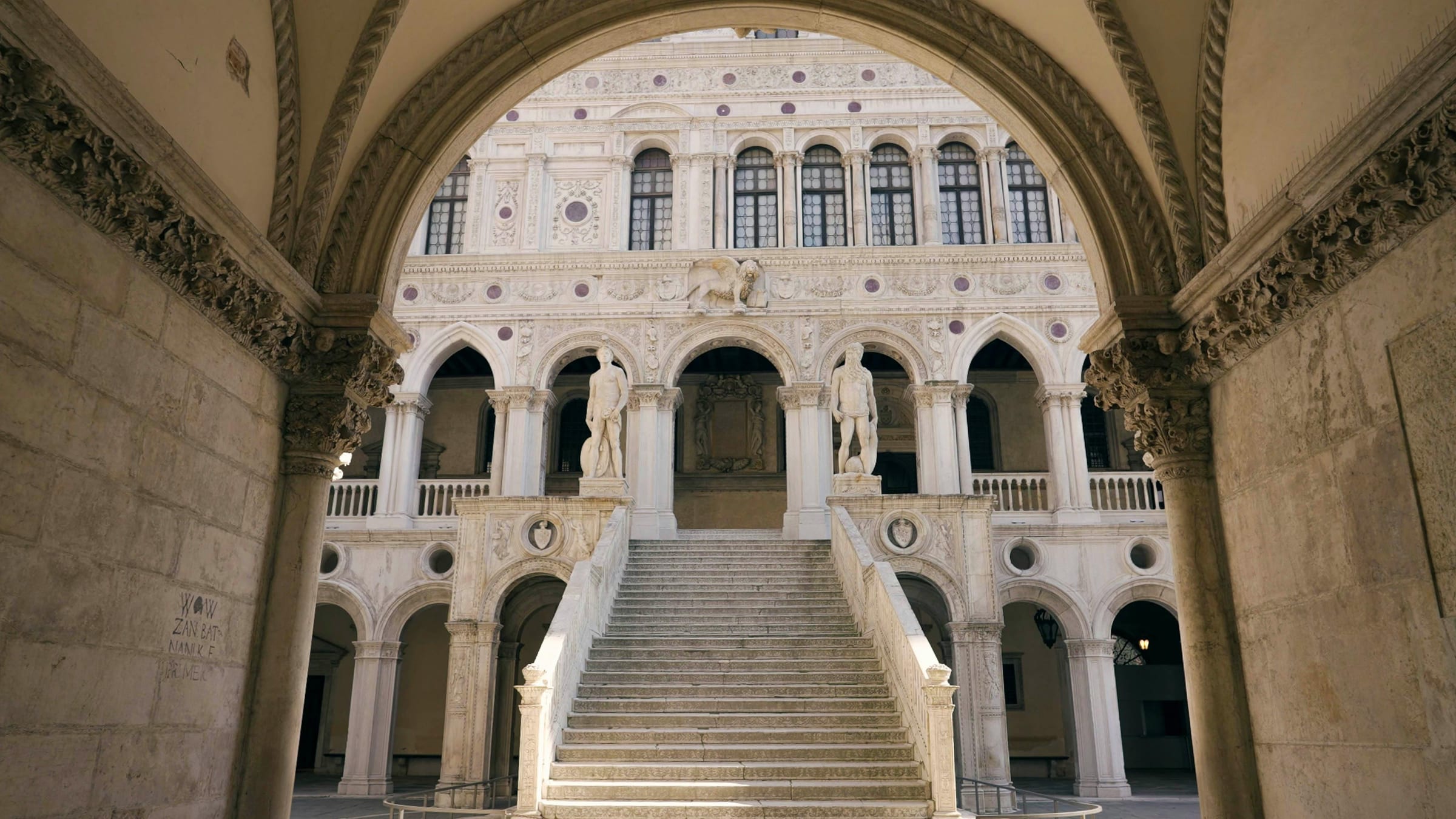 Giants' Staircase in the Doge's Palace courtyard framed by a stone arch